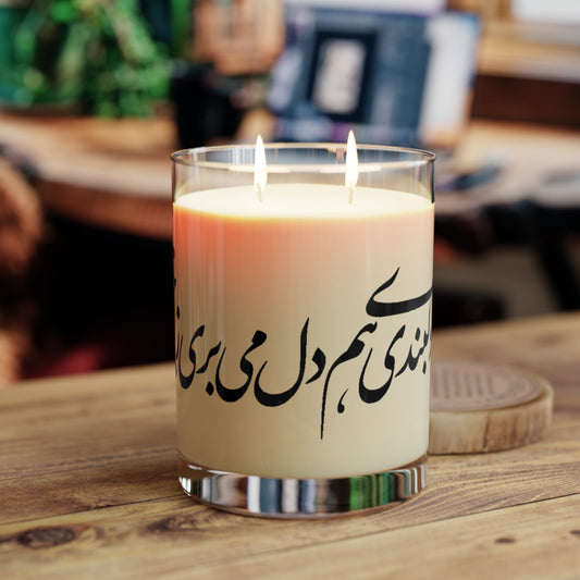 Candle with Farsi text on a wooden surface