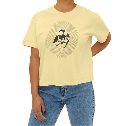 Woman wearing a yellow t-shirt with a graphic design and چو نقطه  in Farsi Persian on the chest on a beige background