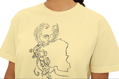 Woman wearing a light yellow t-shirt with a black phoenix design on a white background