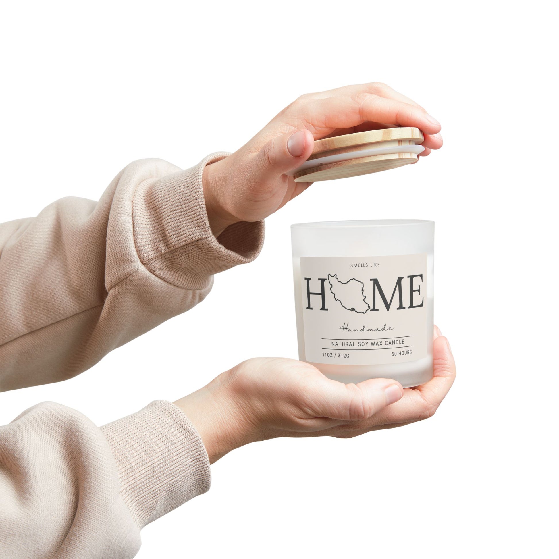 Person holding a Candle labeled smells like 'HOME' and Iran's map on it. 
