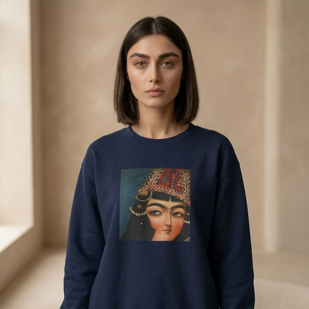 Woman wearing a navy blue sweatshirt with a graphic of a Qajar woman's face on a beige background