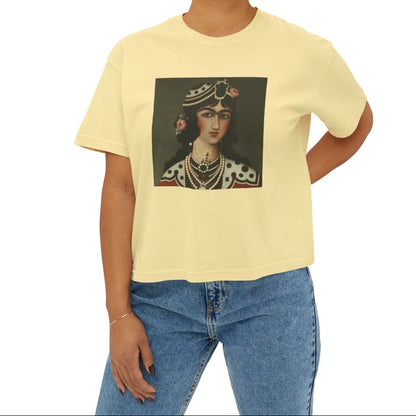 Person wearing a yellow t-shirt with a graphic of a Qajar woman's portrait on the chest on a beige background
