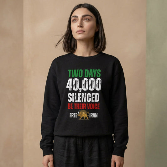 A woman wearing a black crewneck sweatshirt with a political graphic that reads 'TWO DAYS 40,000 SILENCED BE THEIR VOICE FREE IRAN' in green, white, and red, paired with black pants, set against a neutral beige background.