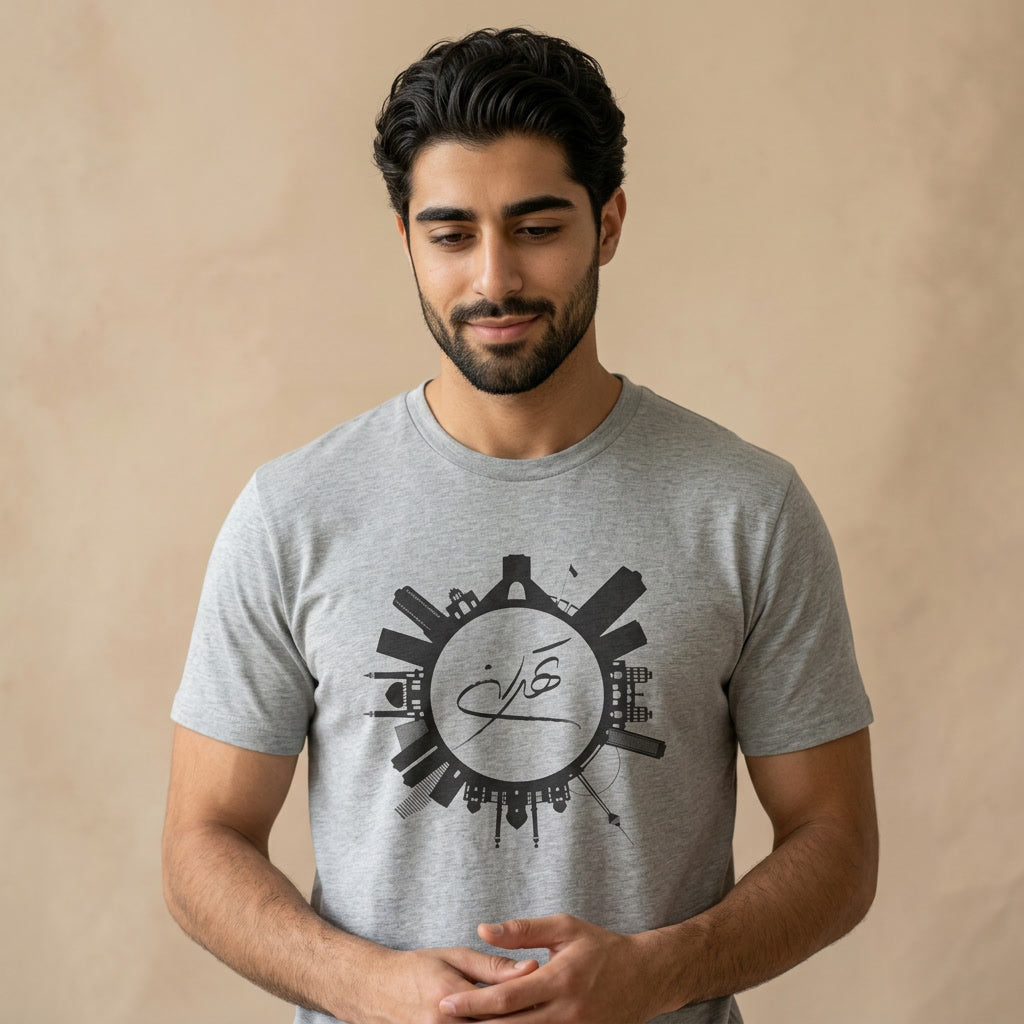 Man wearing a gray t-shirt with graphic of Tehran skyline and Tehran calligraphy in the middle. 