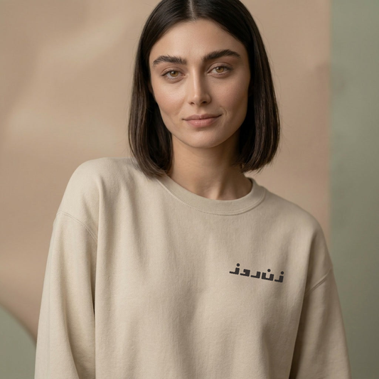 Woman wearing a beige sweatshirt with Zane rooz text on a beige background