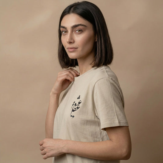 Woman wearing a beige t-shirt with persian calligraphy text on a beige background