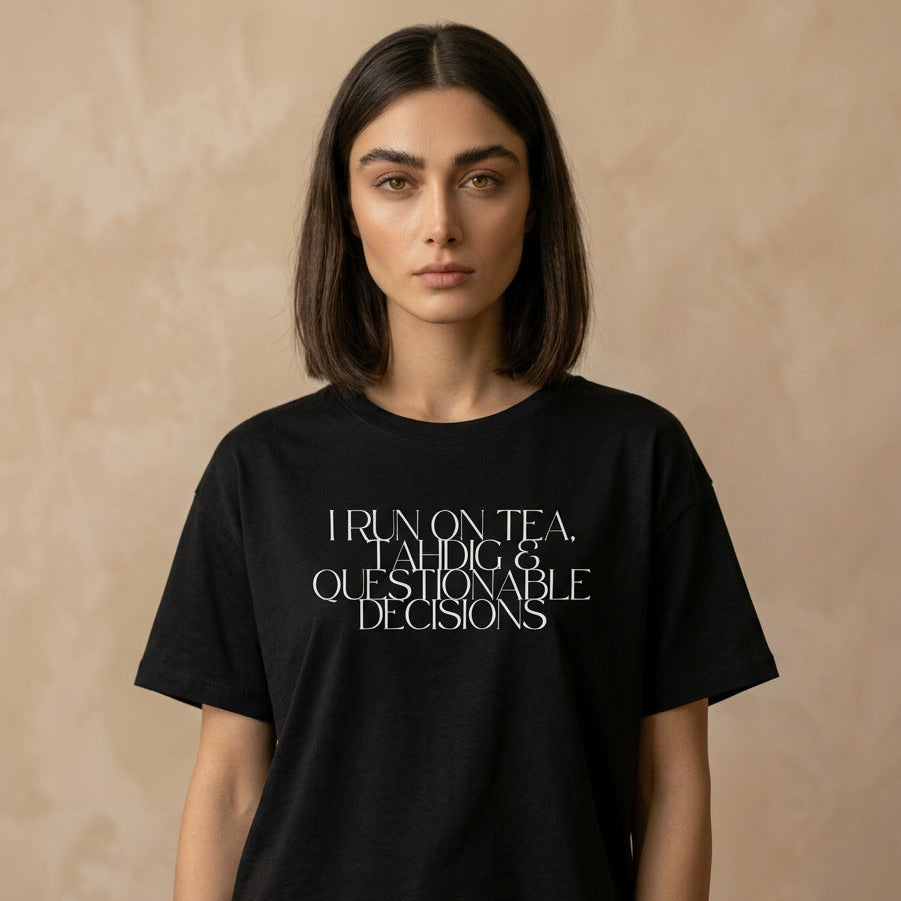 Person wearing a black t-shirt with I run on tea, tahdig & questionable decisions text on the chest. 