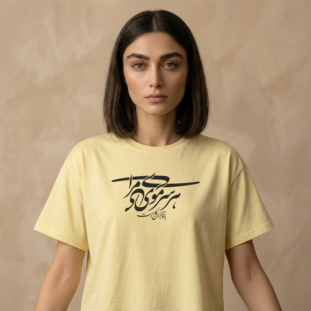 Woman wearing a yellow t-shirt with Persian Farsi calligraphy on a beige background