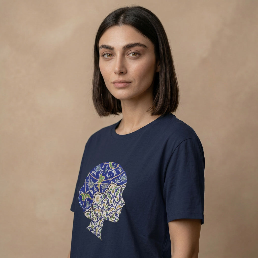 Woman wearing a navy blue t-shirt with a colorful graphic design of persian tile work on a beige background