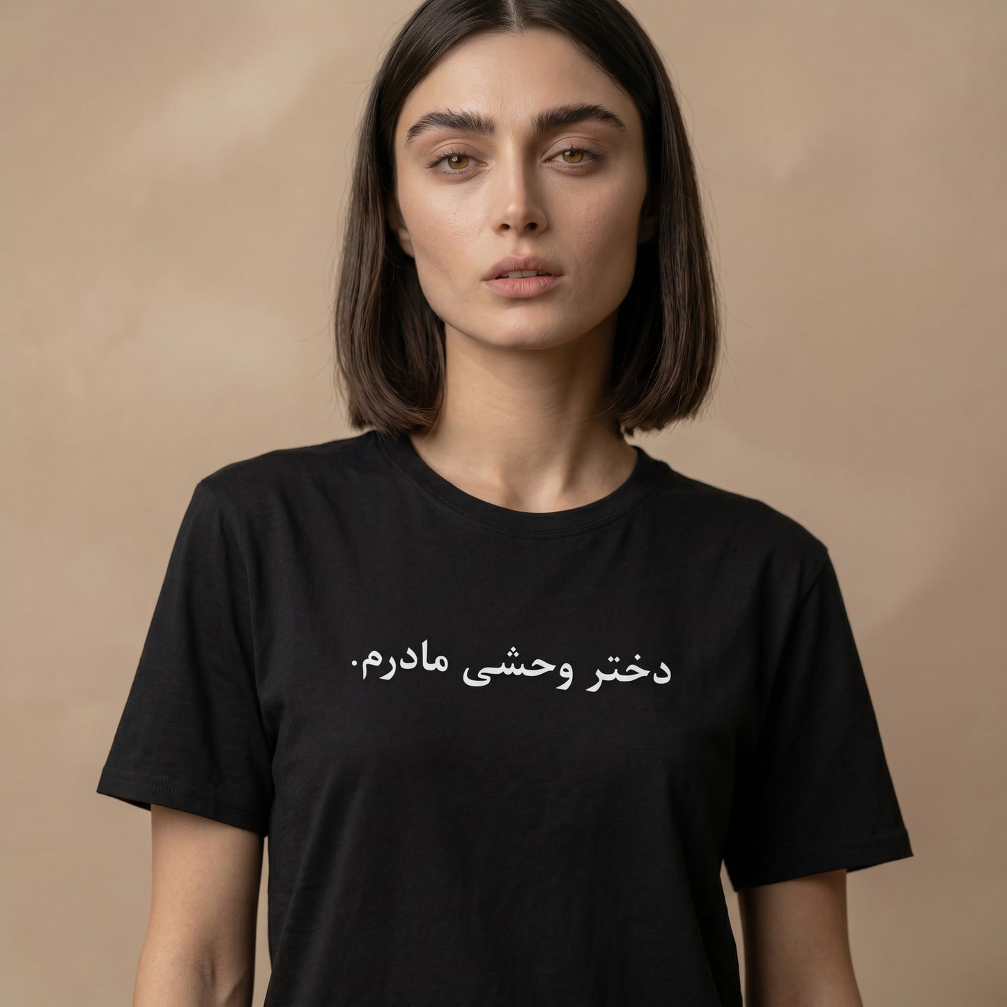 Woman wearing a black t-shirt with farsi text on a beige background